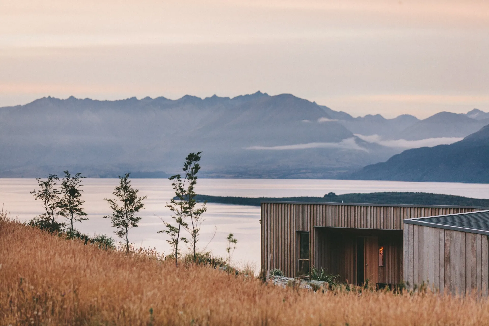 A cabin overlooking mountains and a lake
